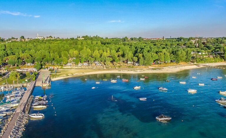 Het strand van Ben je sportief? Dan zit je op Camping Eurocamping Pacengo helemaal goed. Je kunt er tafeltennissen, jeu de boules spelen, tennissen, voetballen en volleyballen. Voor de kids is er een kinderclub die van alles organiseert, van speurtochten tot creatieve workshops. En de speeltuin van 800m² is helemaal de place to be voor kids. 's Avonds is er gezellige animatie, inclusief een kinderdisco! Qua eten is er ook genoeg te kiezen op Camping Eurocamping Pacengo. Smul van de Italiaanse keuken in het restaurant-pizzeria, proef de kindermenu’s of geniet van lokale wijnen. Voor de snelle trek is er een snackbar en zelfs een broodbezorgingsservic, klinkt niet verkeerd toch? Camping Eurocamping Pacengo heeft een heerlijke natuurlijke vibe. Je kunt er overnachten in moderne stacaravans, mobile homes of natuurlijk een eigen staanplaats boeken. Ook ligt het stadje Pacengo ligt om de hoek, vol met leuke winkels, cafés en restaurants. Stap op de fiets en ontdek schilderachtige stadjes langs het meer, zoals Lazise, Peschiera en natuurlijk Bardolino. Neem een kijkje bij de verschillende reisaanbieders en boek jouw verblijf op Camping Eurocamping Pacengo voor een heerlijke tijd aan het Gardameer!