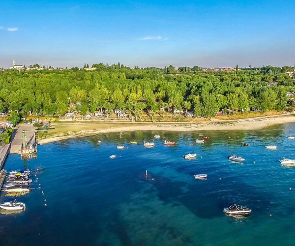 Het strand van Ben je sportief? Dan zit je op Camping Eurocamping Pacengo helemaal goed. Je kunt er tafeltennissen, jeu de boules spelen, tennissen, voetballen en volleyballen. Voor de kids is er een kinderclub die van alles organiseert, van speurtochten tot creatieve workshops. En de speeltuin van 800m² is helemaal de place to be voor kids. 's Avonds is er gezellige animatie, inclusief een kinderdisco! Qua eten is er ook genoeg te kiezen op Camping Eurocamping Pacengo. Smul van de Italiaanse keuken in het restaurant-pizzeria, proef de kindermenu’s of geniet van lokale wijnen. Voor de snelle trek is er een snackbar en zelfs een broodbezorgingsservic, klinkt niet verkeerd toch? Camping Eurocamping Pacengo heeft een heerlijke natuurlijke vibe. Je kunt er overnachten in moderne stacaravans, mobile homes of natuurlijk een eigen staanplaats boeken. Ook ligt het stadje Pacengo ligt om de hoek, vol met leuke winkels, cafés en restaurants. Stap op de fiets en ontdek schilderachtige stadjes langs het meer, zoals Lazise, Peschiera en natuurlijk Bardolino. Neem een kijkje bij de verschillende reisaanbieders en boek jouw verblijf op Camping Eurocamping Pacengo voor een heerlijke tijd aan het Gardameer!