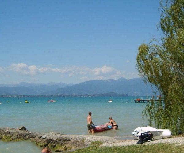 Het zandstrand aan het gardameer op camping san francesco campingvillage